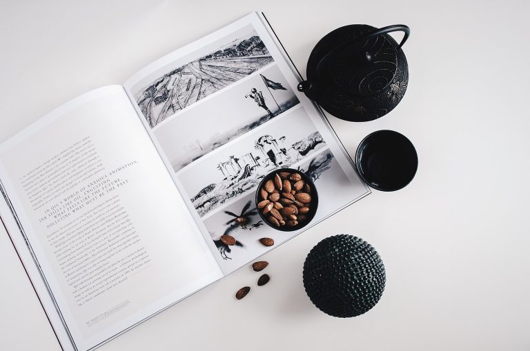 Almendras en un cuenco junto a una tetera y una taza de té sobre una mesa blanca